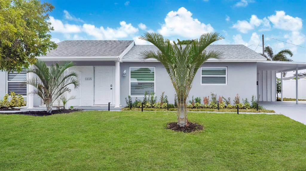 A single-story gray house with a white front door, palm trees, and a carport — 1115 Stillwater Drive, Jupiter FL 33458, JUPITER, FL