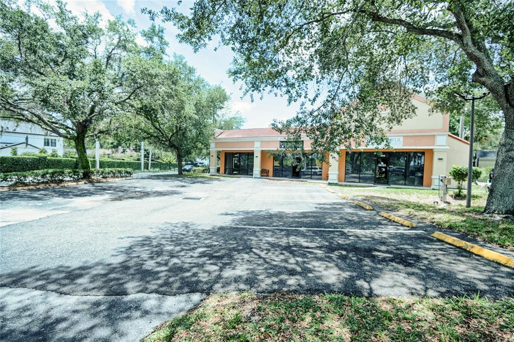 A commercial building with a parking lot and large trees in front — 5544 HANSEL AVENUE UNIT 1, ORLANDO, FL