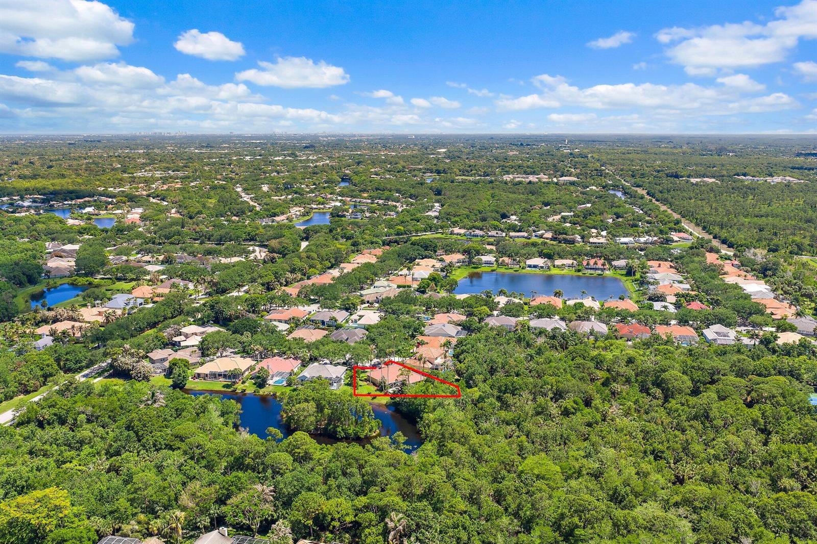 An aerial view shows a house outlined in red, situated near a lake and trees — 19189 Tamara Lane, Jupiter FL 33458, JUPITER, FL
