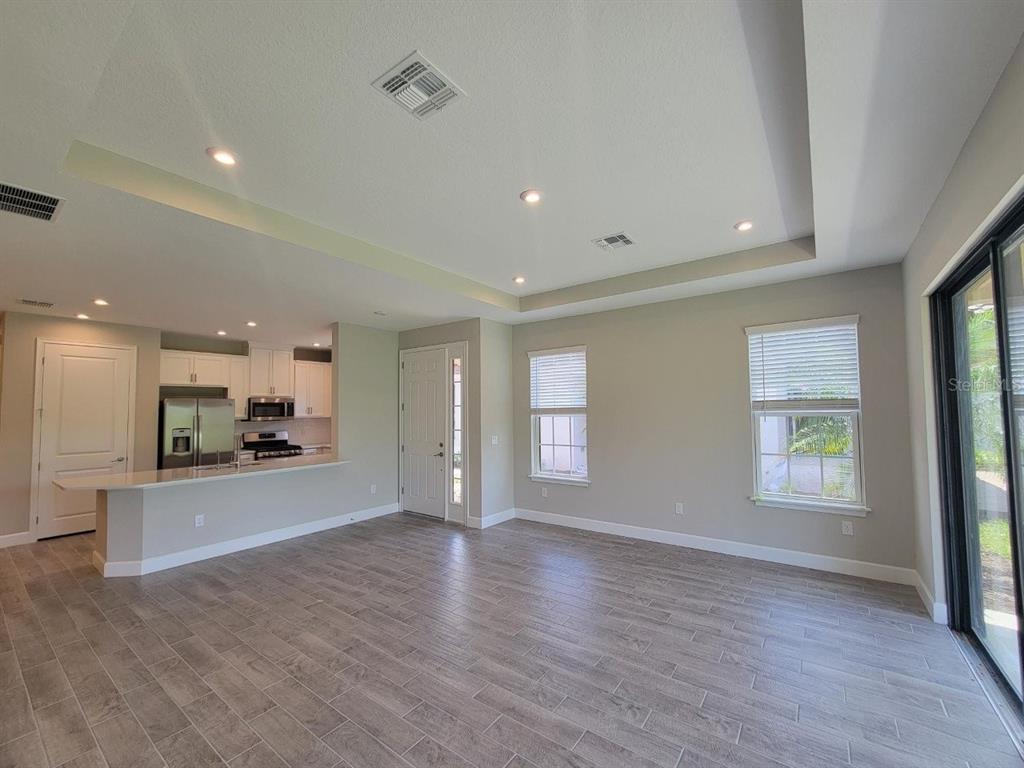 An open-concept living area features light gray tile flooring, recessed lighting, and a kitchen island — 5331 RUSHMERE COURT, PALMETTO, FL
