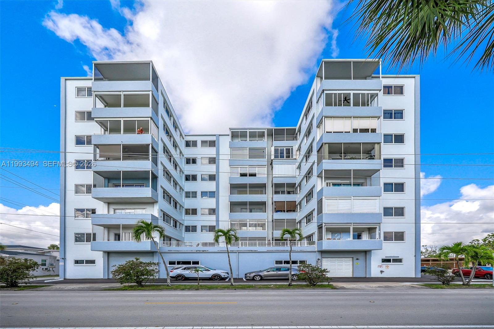 A multi-story blue apartment building features balconies and a ground-level parking area — 1700 Pierce St # 804, Hollywood FL 33020, HOLLYWOOD, FL