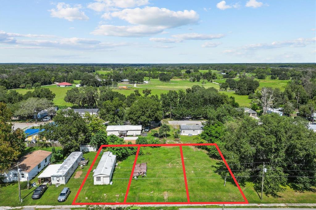 An aerial view shows three adjacent vacant lots with a small structure and mobile home — 636 3RD STREET, POLK CITY, FL