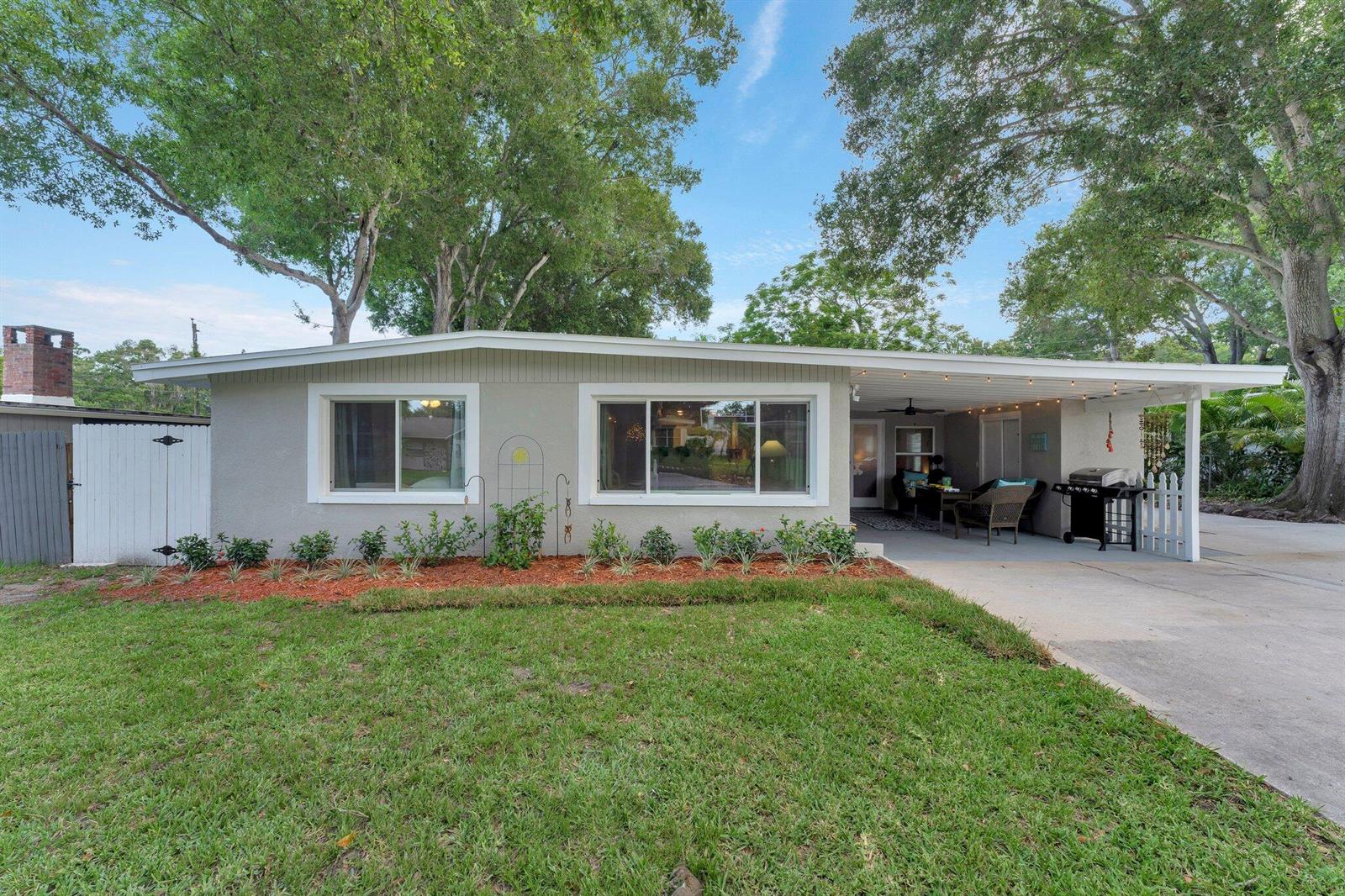 A single-story gray house with a front lawn, landscaping, and a covered carport — 1555 Shirley Place, Largo FL 33770, LARGO, FL