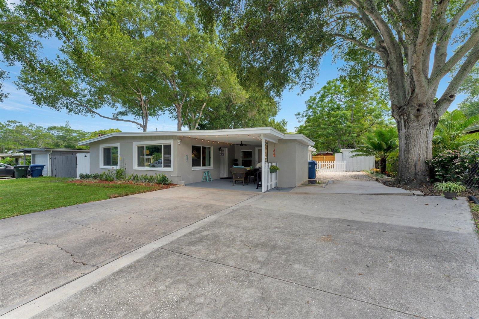 A single-story house with a concrete driveway, a covered carport, and large shade trees — 1555 Shirley Place, Largo FL 33770, LARGO, FL