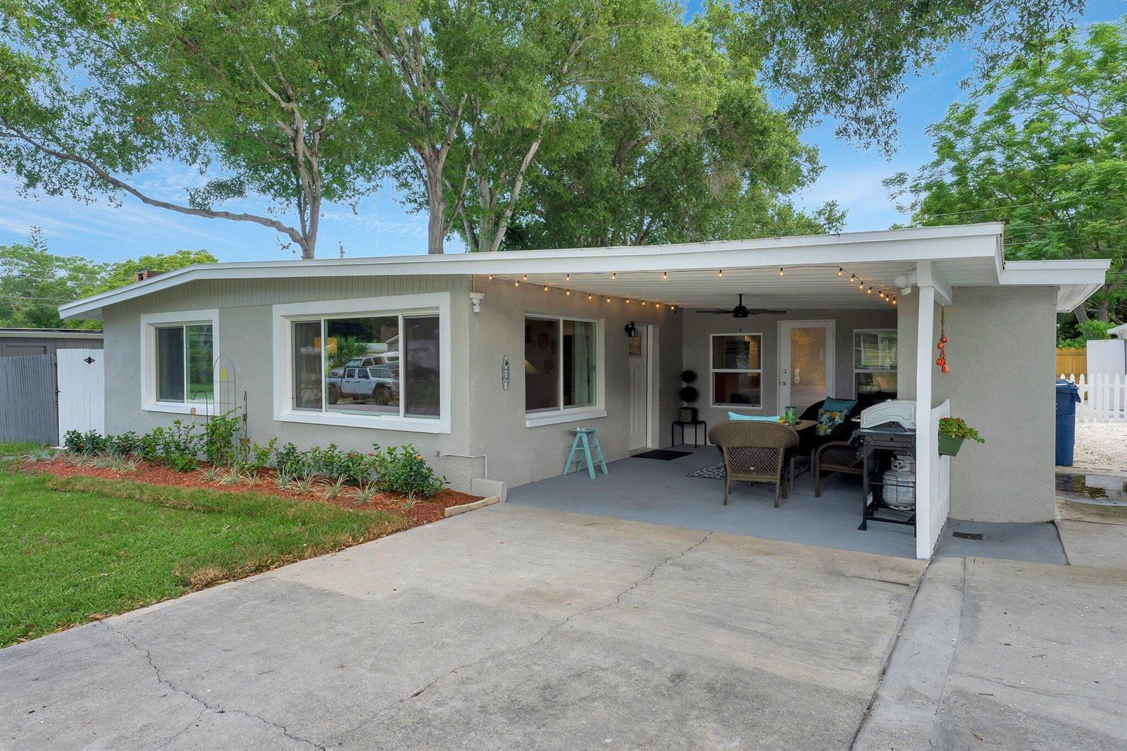 A single-story house with a gray exterior, a concrete driveway, and a covered front patio — 1555 Shirley Place, Largo FL 33770, LARGO, FL