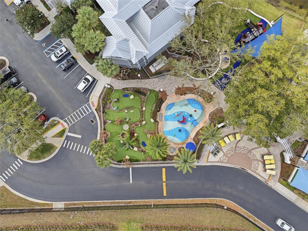 Aerial view of a miniature golf course, splash pad, and parking lot near a building — 10556 EBB TIDE LANE, ORLANDO, FL