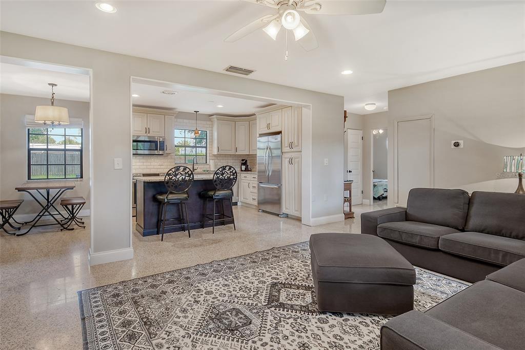 An open-concept living room and kitchen feature light-colored walls, terrazzo flooring, and a dark island — 2309 LYNN STREET, SARASOTA, FL