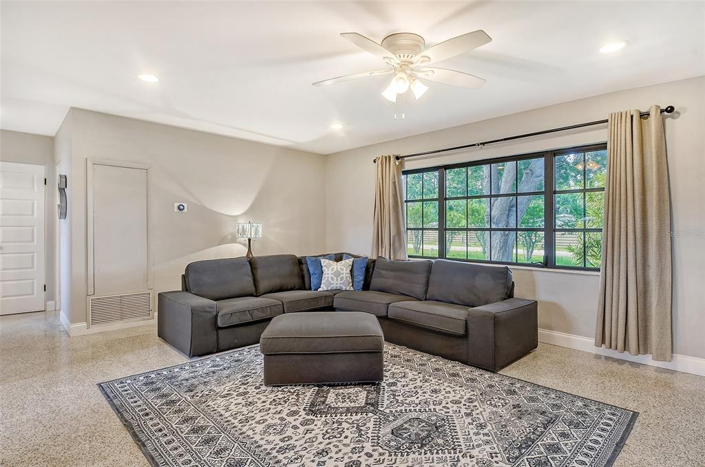 A living room features a gray sectional sofa, a patterned area rug, and a large window — 2309 LYNN STREET, SARASOTA, FL
