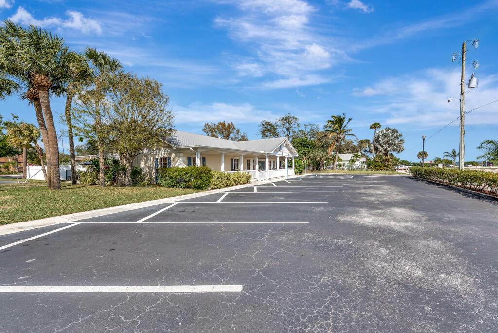 A single-story commercial building with a covered porch sits beside an empty asphalt parking lot — SEBASTIAN, FL