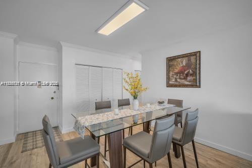 A dining room features a glass-topped table with six gray chairs and a wall painting — 1950 S Ocean Dr # 6K, Hallandale Beach FL 33009, HALLANDALE BEACH, FL