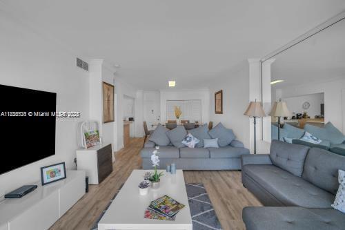 A living room features a gray sectional sofa, a white coffee table, and a television — 1950 S Ocean Dr # 6K, Hallandale Beach FL 33009, HALLANDALE BEACH, FL