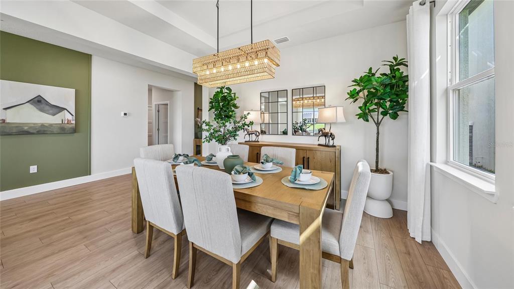 A dining room features a wooden table, six upholstered chairs, and a rectangular woven chandelier — 12776 NW 17TH PLACE, NEWBERRY, FL