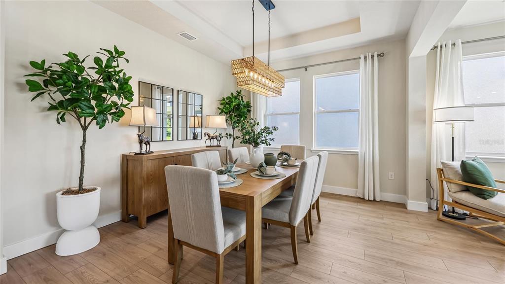 A dining room features a wooden table, six upholstered chairs, a sideboard, and a chandelier — 12776 NW 17TH PLACE, NEWBERRY, FL