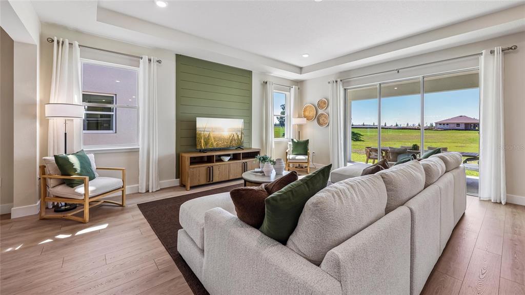 A living room features light wood floors, a green shiplap accent wall, and sliding glass doors — 12776 NW 17TH PLACE, NEWBERRY, FL