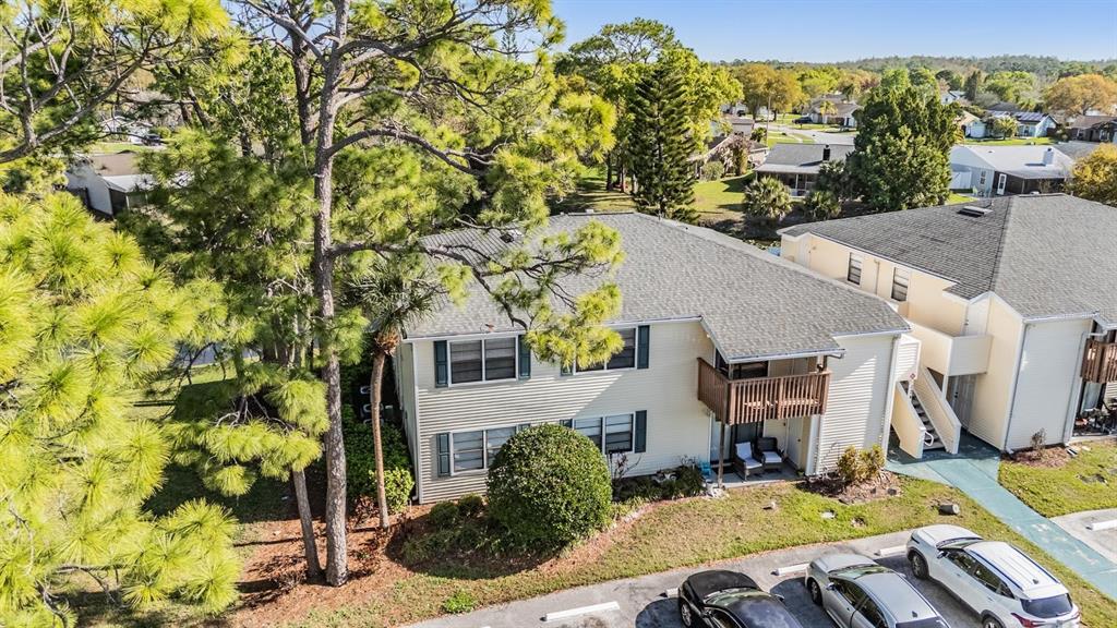 An aerial view of a two-story apartment building with light siding and a balcony — 124 LOBLOLLY COURT UNIT H, OLDSMAR, FL