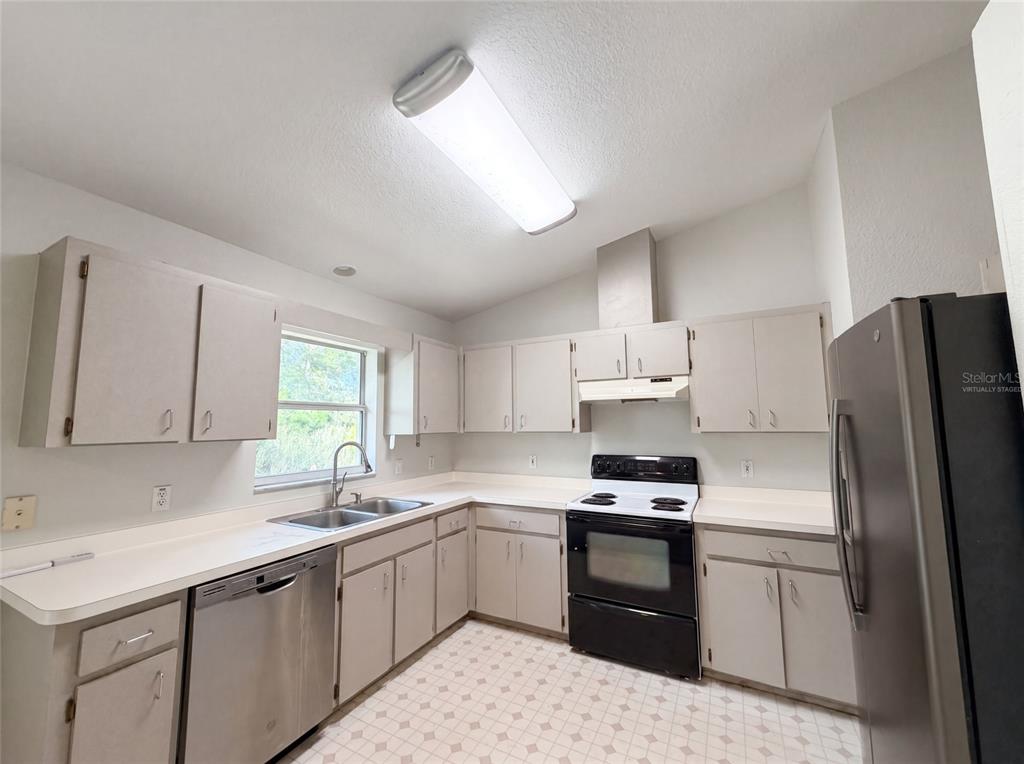 A kitchen with light-colored cabinets, white countertops, a double sink, and stainless steel appliances — 17956 SW 25TH AVENUE ROAD, OCALA, FL