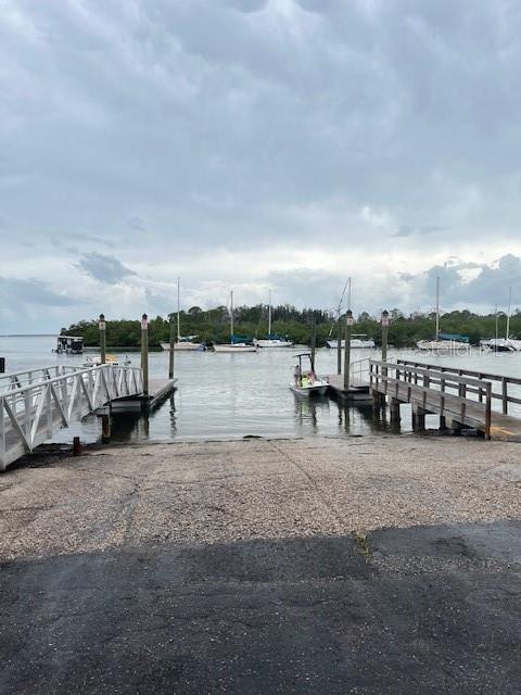 A boat ramp leads into a waterway with docks and several boats moored in the distance — 1045 HICKORY LANE, HOLIDAY, FL