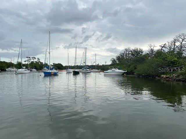 Several sailboats and a motorboat are moored in a calm waterway near a wooded shoreline — 1045 HICKORY LANE, HOLIDAY, FL
