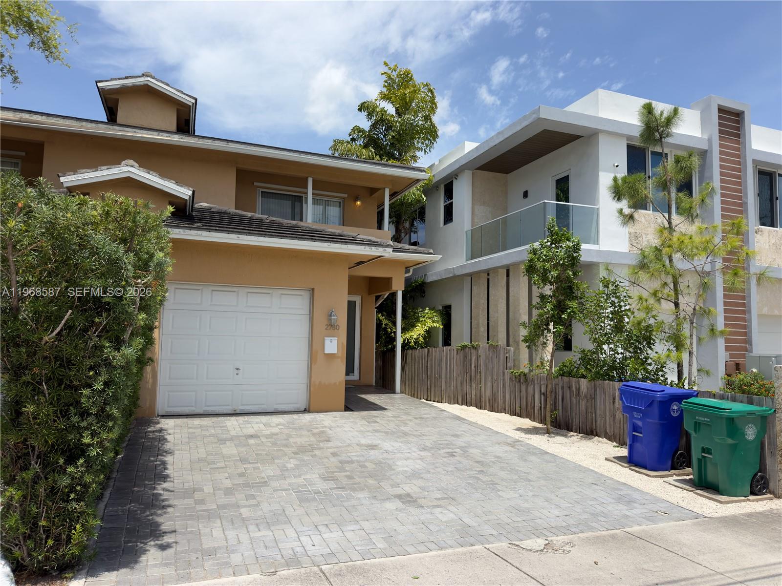 A tan house with a paved driveway sits next to a modern white two-story home — 2780 SW 33 AVE, Miami FL 33133, MIAMI, FL