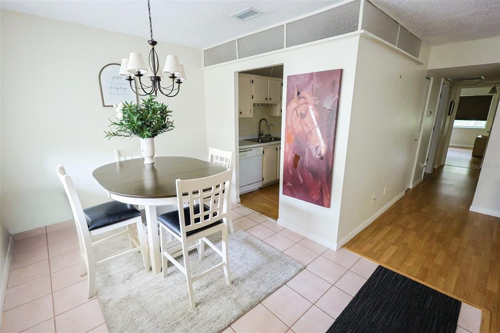 A dining area with a round table and chairs sits adjacent to a kitchen doorway — 1235 S HIGHLAND AVENUE UNIT 4-306, CLEARWATER, FL