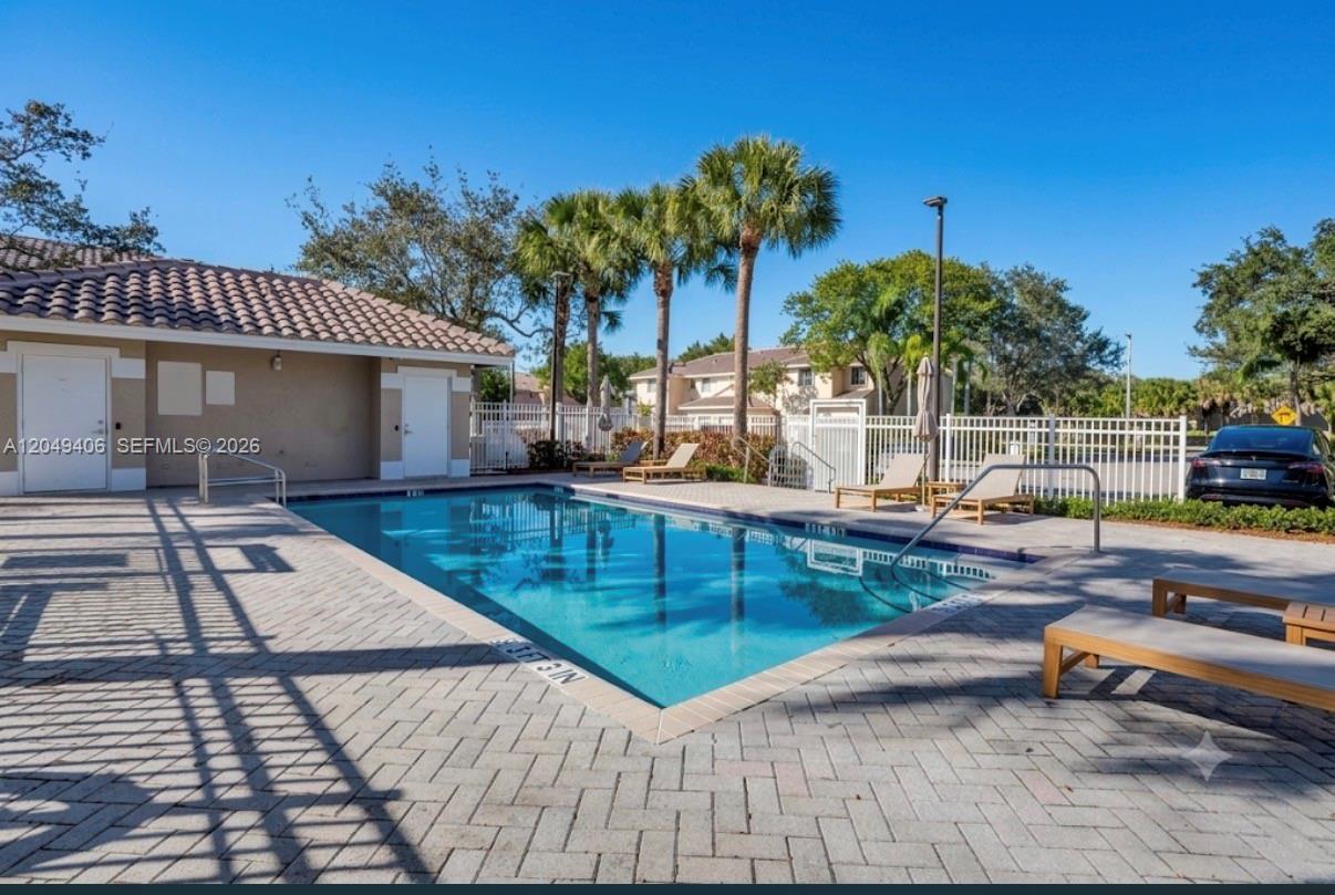 A rectangular swimming pool with lounge chairs on a paved deck under palm trees — 4070 NW 92nd Ave, Sunrise FL 33351, SUNRISE, FL