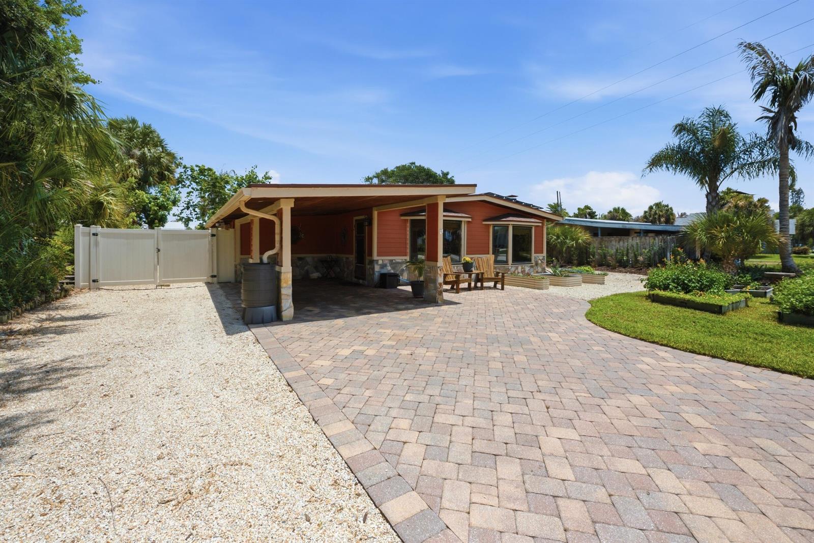 A house with a paved driveway, a covered carport, and a gravel side yard — 1055 S Brevard Avenue, Cocoa Beach FL 32931, COCOA BEACH, FL