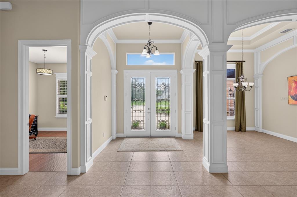 A tiled foyer features a double front door with glass inserts and arched white columns — 6 SCARLET OAK CIRCLE, PALM COAST, FL