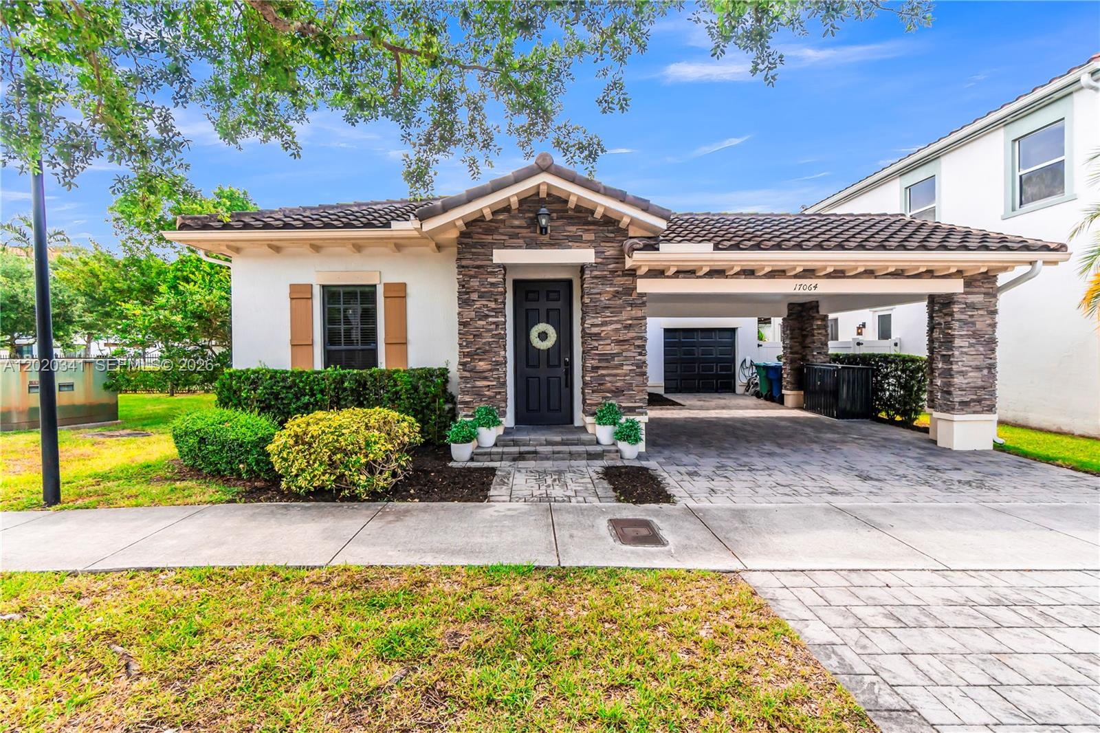 A single-story house features a stone facade, a covered carport, and a dark front door — 17064 SW 90th Way, Miami FL 33196, MIAMI, FL