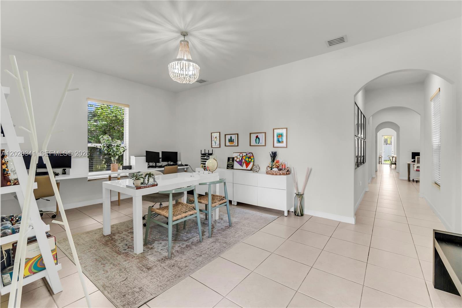 A bright home office features a white desk, a chandelier, and tiled flooring — 17064 SW 90th Way, Miami FL 33196, MIAMI, FL