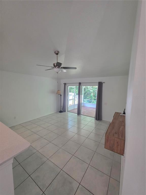 A living room with white walls, light tile flooring, a ceiling fan, and sliding glass doors — 2930 RIVERS END ROAD, ORLANDO, FL