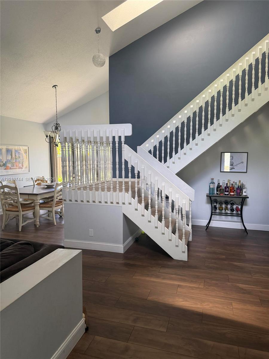 A living area features a white staircase with wooden treads and a dark accent wall — 1481 NW 104th Ave, Plantation FL 33322, PLANTATION, FL