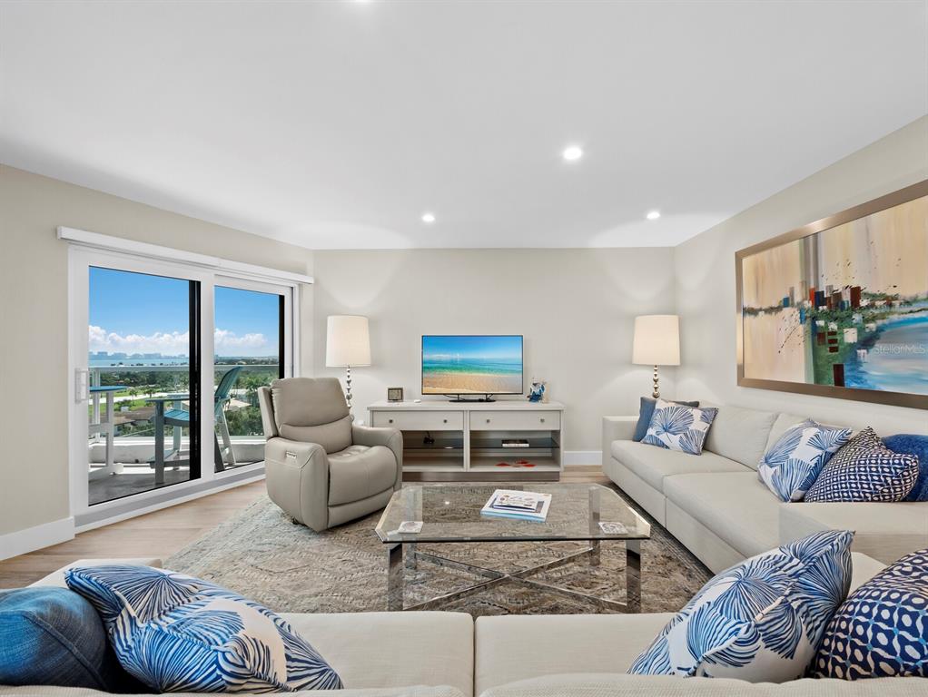 A living room features a beige sofa, a recliner, a glass coffee table, and a balcony — 1050 LONGBOAT CLUB ROAD UNIT 903, LONGBOAT KEY, FL
