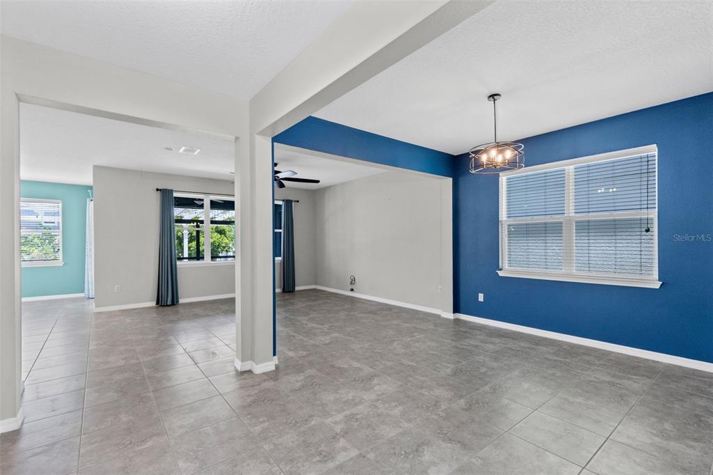 A dining area with blue walls, tile flooring, and a chandelier near an entryway — 2819 STONEGATE DRIVE, OCOEE, FL