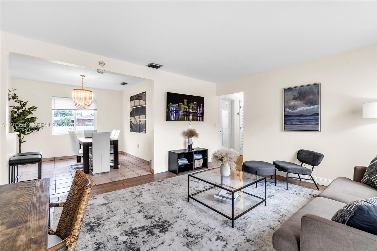 A living room and dining area feature tile and wood flooring with modern furniture — 13405 NW 6th Ave, North Miami FL 33168, NORTH MIAMI, FL