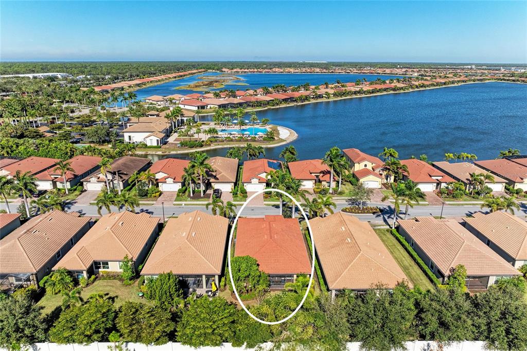 An aerial view shows a residential neighborhood with a circled single-family home near a lake — 131 MARAVIYA BOULEVARD, NOKOMIS, FL