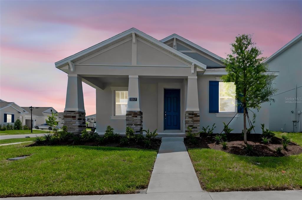 A single-story house with a blue front door, stone-accented columns, and a covered porch — 5237 WAYPOINTE BOULEVARD, APOPKA, FL