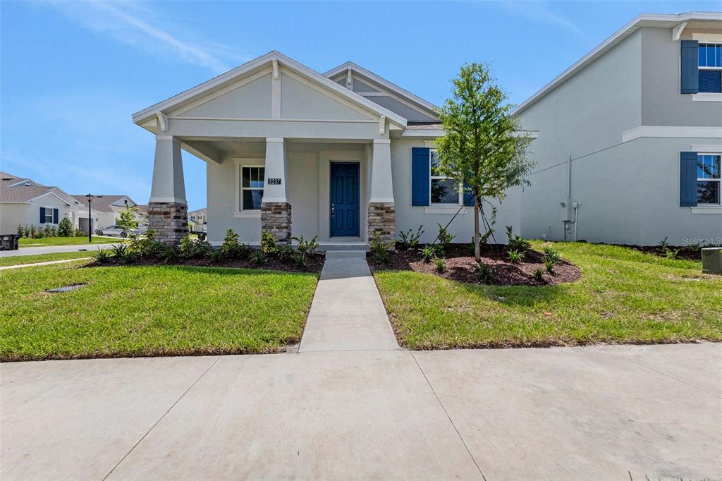 A single-story house with a covered front porch, stone columns, and blue shutters — 5237 WAYPOINTE BOULEVARD, APOPKA, FL