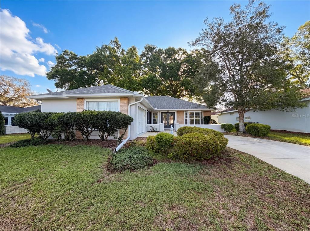 A single-story house with a light-colored exterior, a driveway, and manicured landscaping — 7319 SW 115TH PLACE, OCALA, FL