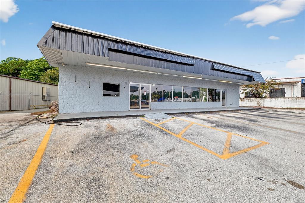 A single-story commercial building with a stone facade and a large black metal awning — 1526 US HIGHWAY 441, LEESBURG, FL