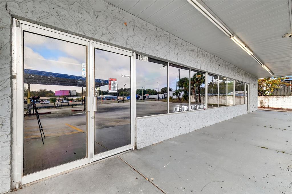 The exterior of a commercial building features a glass storefront, a concrete walkway, and a canopy — 1526 US HIGHWAY 441, LEESBURG, FL