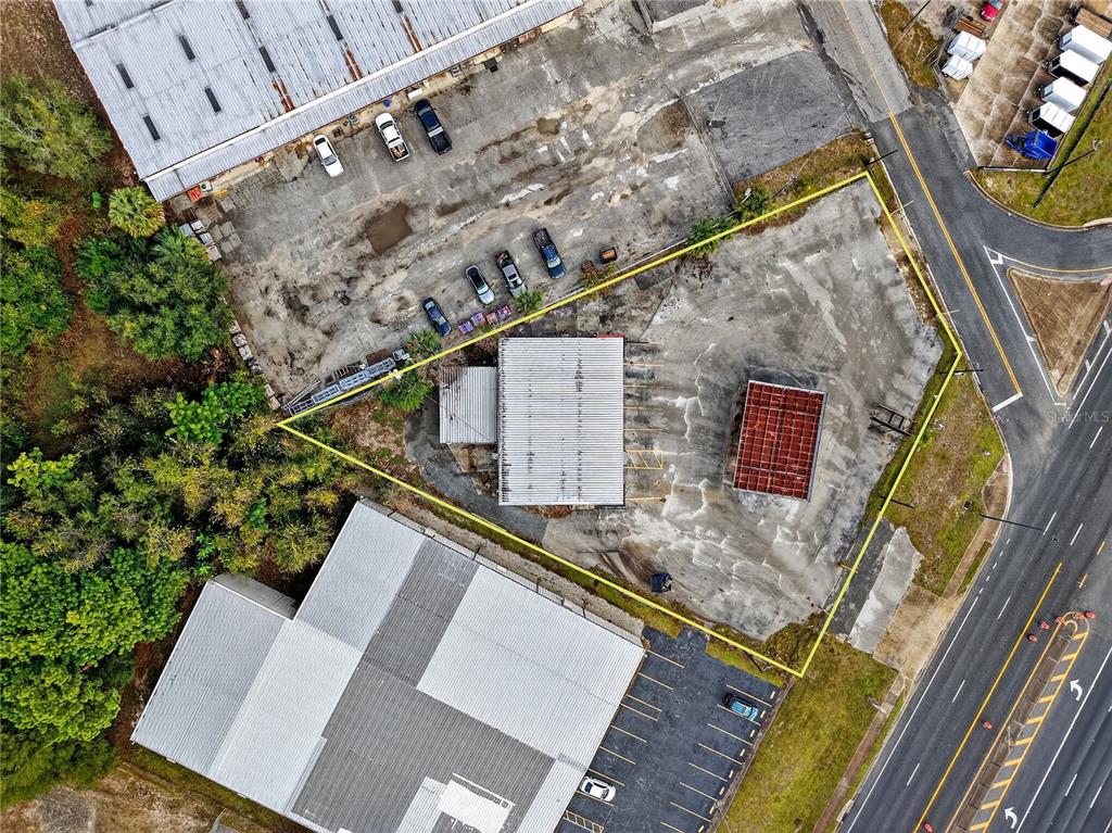 This aerial view shows a commercial property with two buildings and a parking lot — 1526 US HIGHWAY 441, LEESBURG, FL