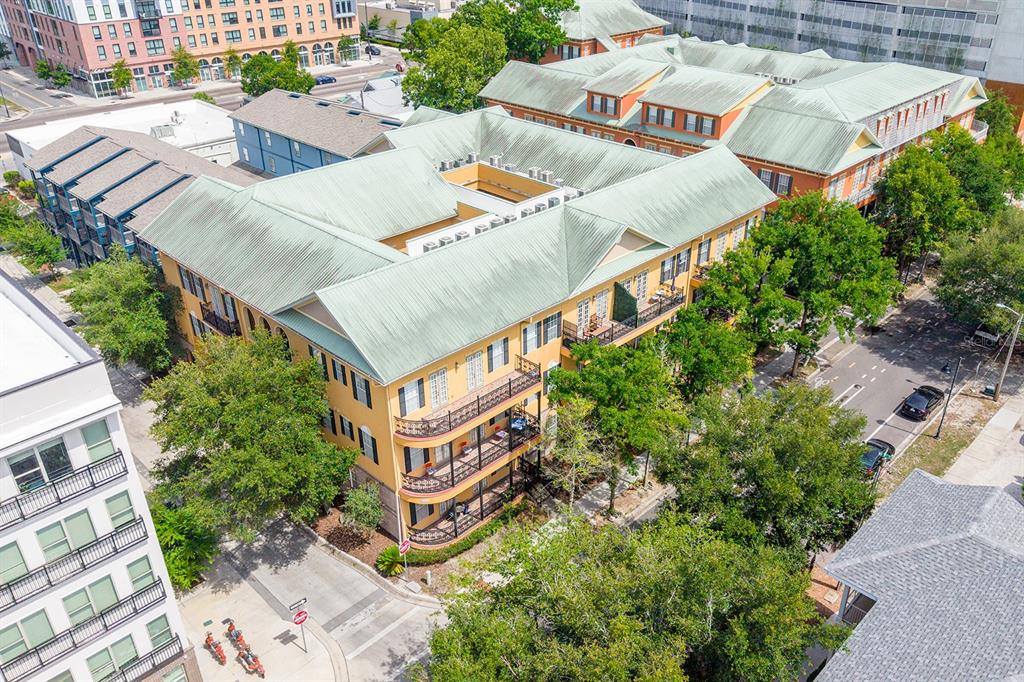 An aerial view shows a multi-story yellow apartment building with green metal roofs — 325 NW 14TH STREET UNIT 205, GAINESVILLE, FL