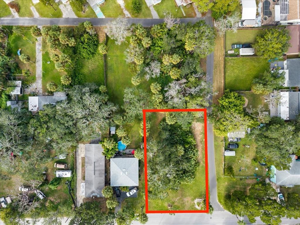 An aerial view shows a rectangular, tree-covered vacant lot outlined in red — 7601 PIER ROAD, PORT RICHEY, FL
