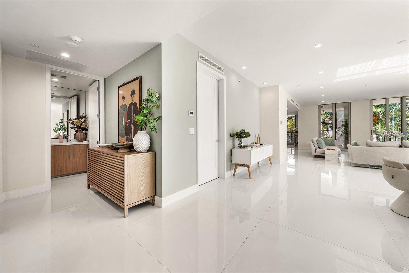 A bright, modern entryway with white tile floors leads into an open-concept living area — 475 E Royal Palm Road # 206, Boca Raton FL 33432, BOCA RATON, FL