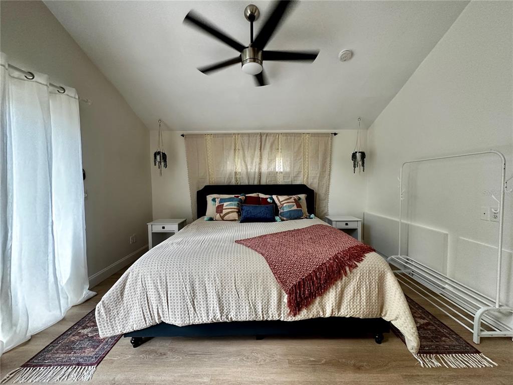 A bedroom features a bed with a patterned throw, two nightstands, and a ceiling fan — 1222 E CRAWFORD STREET UNIT B, TAMPA, FL