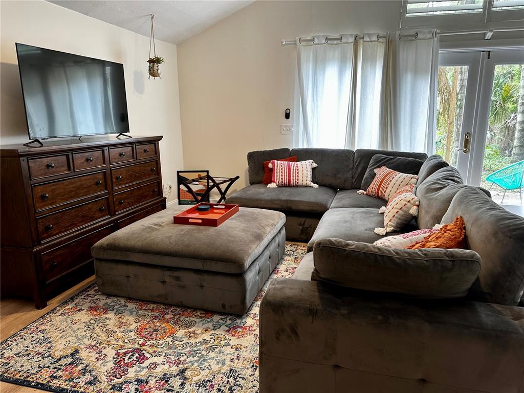 A living room features a large grey sectional, a matching ottoman, and a wooden dresser — 1222 E CRAWFORD STREET UNIT B, TAMPA, FL
