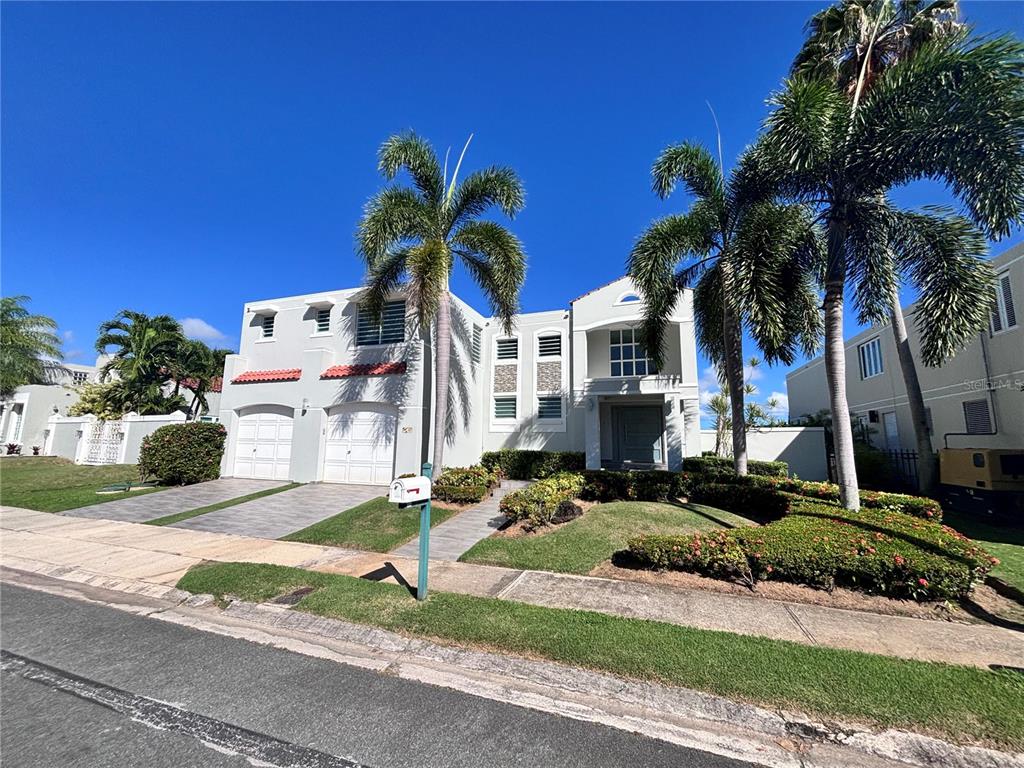 A two-story house with a two-car garage, palm trees, and a landscaped front yard — Calle PITIERRE, SAN JUAN, PR