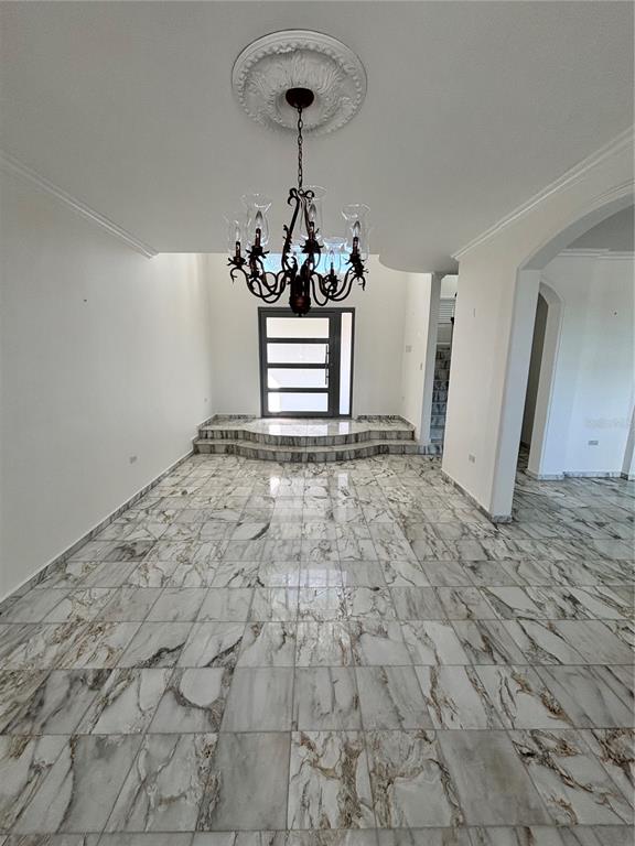 A foyer with marble tile flooring, a tiered entrance, and a decorative chandelier — Calle PITIERRE, SAN JUAN, PR