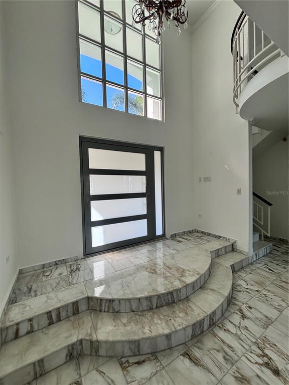 A grand foyer features marble flooring, a curved tiered platform, and a modern front door — Calle PITIERRE, SAN JUAN, PR