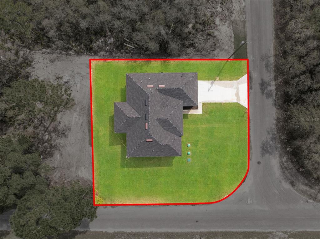 An aerial view shows a house situated on a corner lot with a red boundary outline — 33 FISHER PLACE, OCKLAWAHA, FL